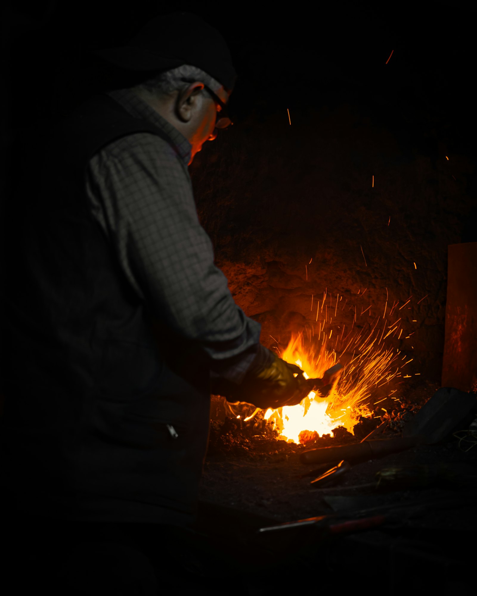 Blacksmith forging glowing metal, sparks flying